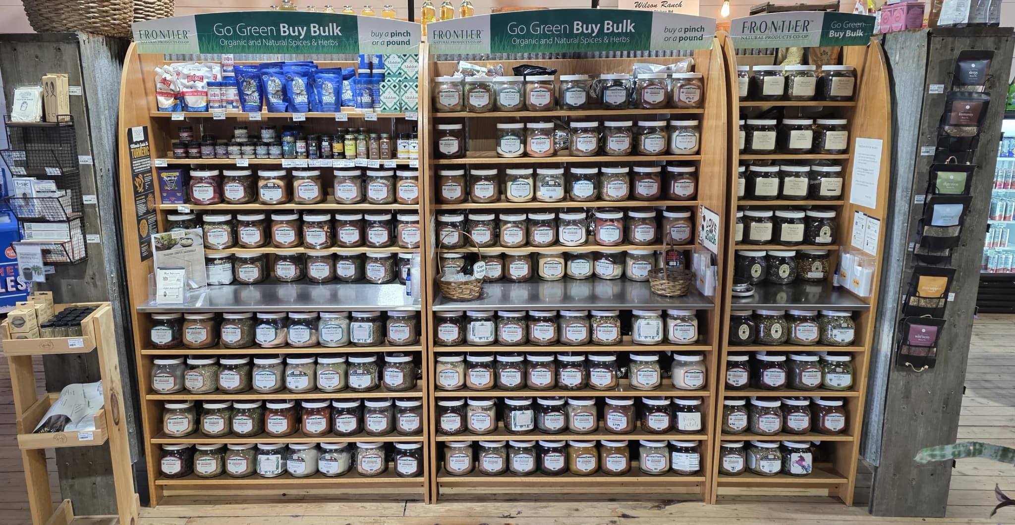 Wall of bulk organic spices and herbs in labeled jars